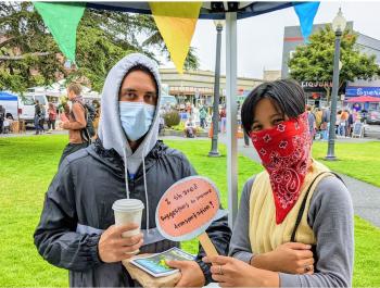 Two young adults provide feedback at HCAOG's pop-up at the Arcata Farmers Market